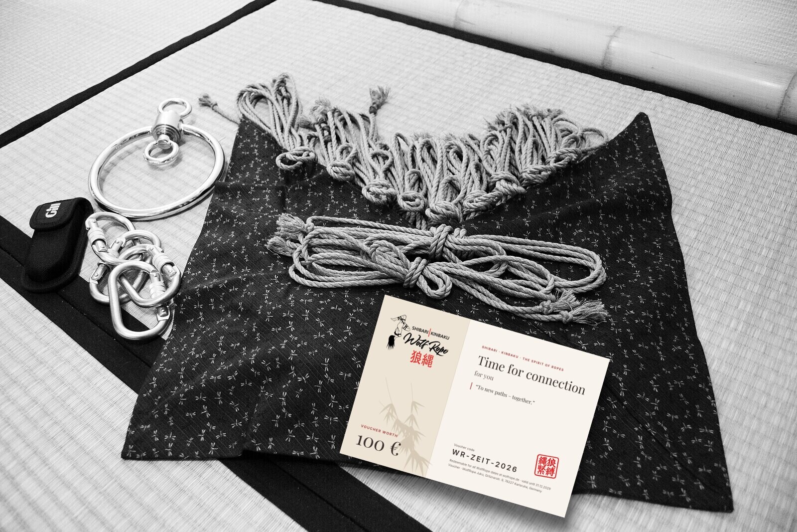 WolfRope voucher worth 100 € next to jute ropes, suspension ring and carabiners on tatami