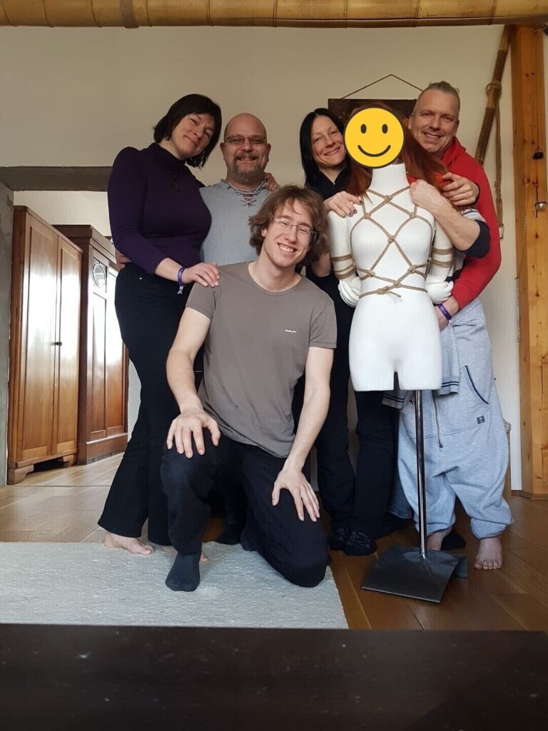 Gruppenfoto unter Freunden neben einer Schaufensterpuppe mit Seilharness