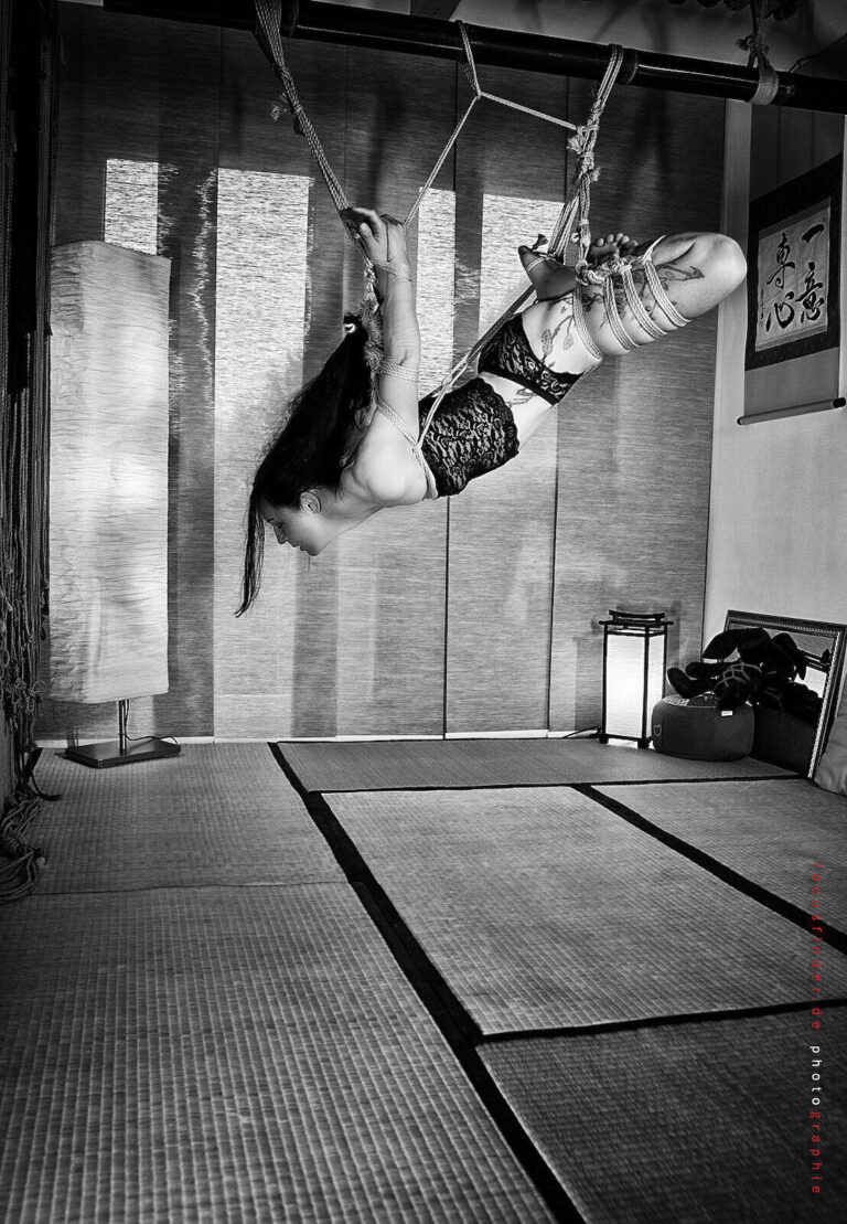 Hängefesselung in schwarzer Spitze im Dojo, Schwarzweiß
