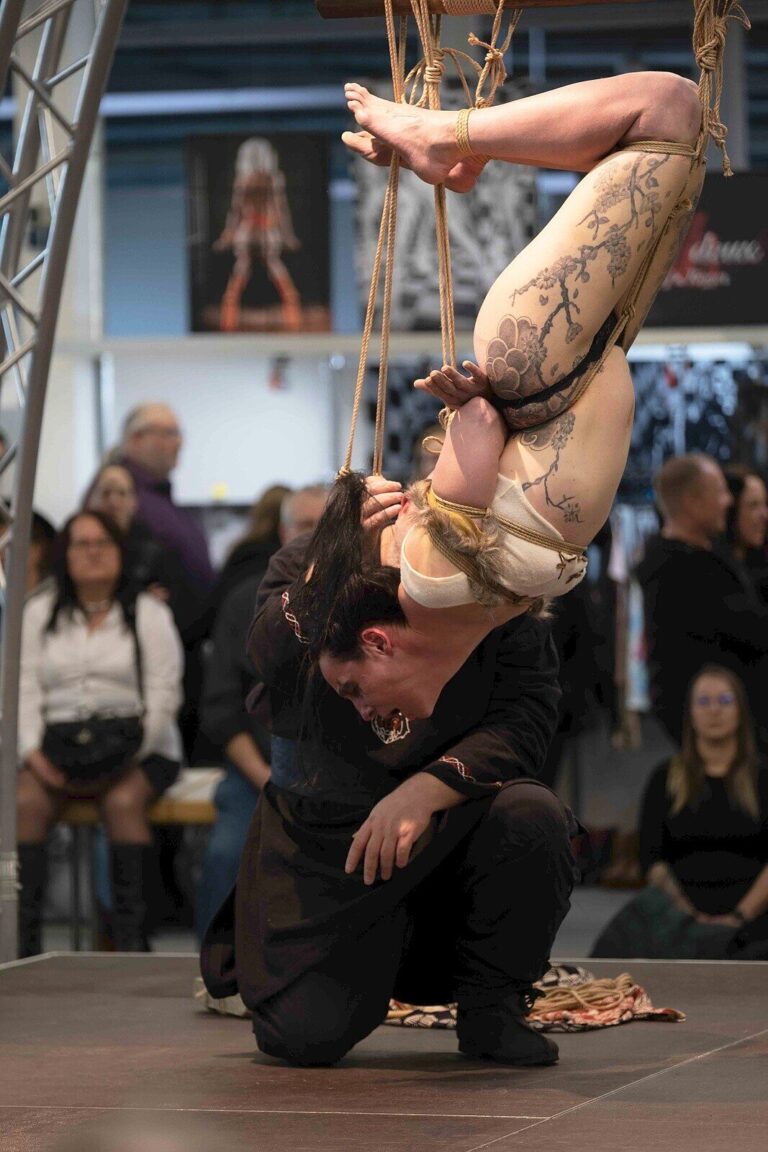 Kopfüber-Hängefesselung im Fell-Kostüm, der Rigger kniet darunter, Kopf an Kopf, Bondage-Fetish-World Spring 2023