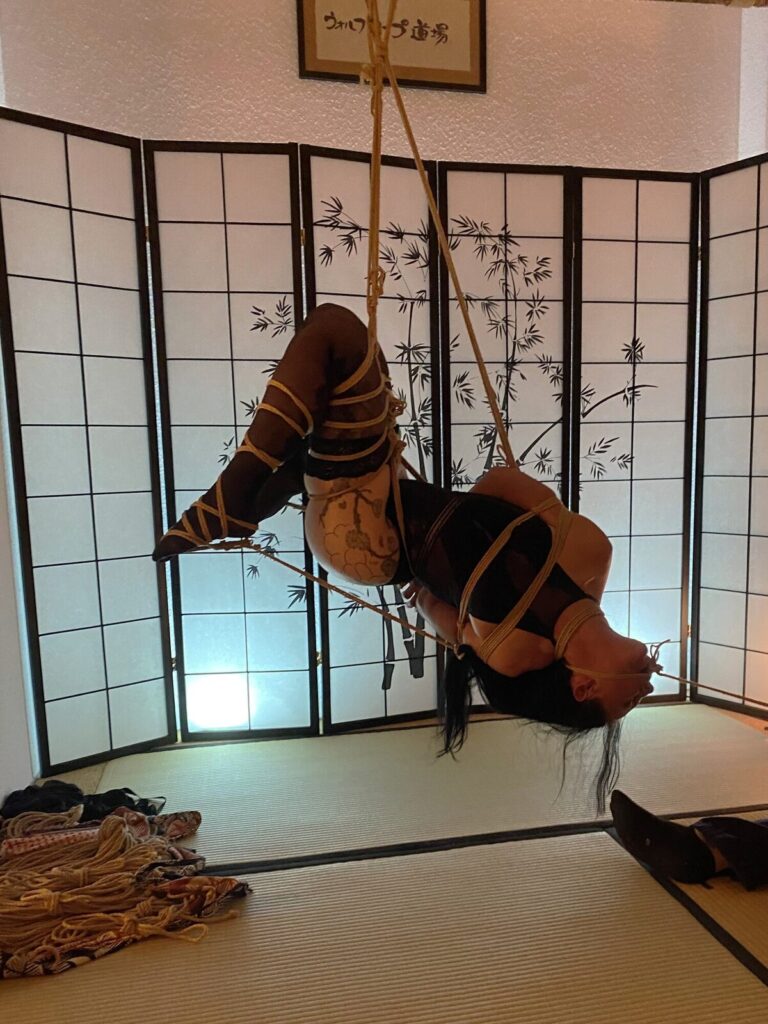 Liegende Hängefesselung vor einer Shoji-Wand mit Bambusmotiv
