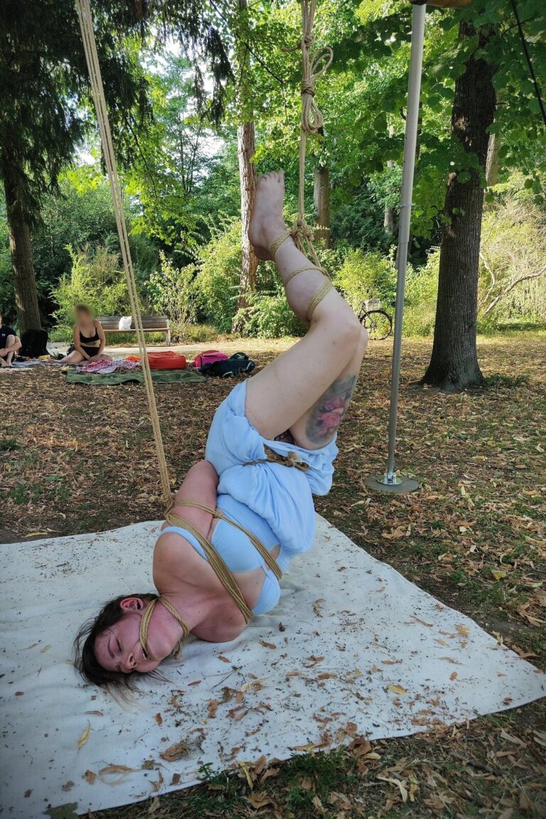 Im Park: kopfüber, die Schultern auf der Decke, die Beine nach oben gebunden
